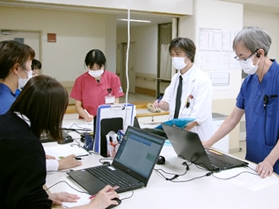 介護施設のスタッフが会議室でパソコンを使用して業務打ち合わせを行っている様子